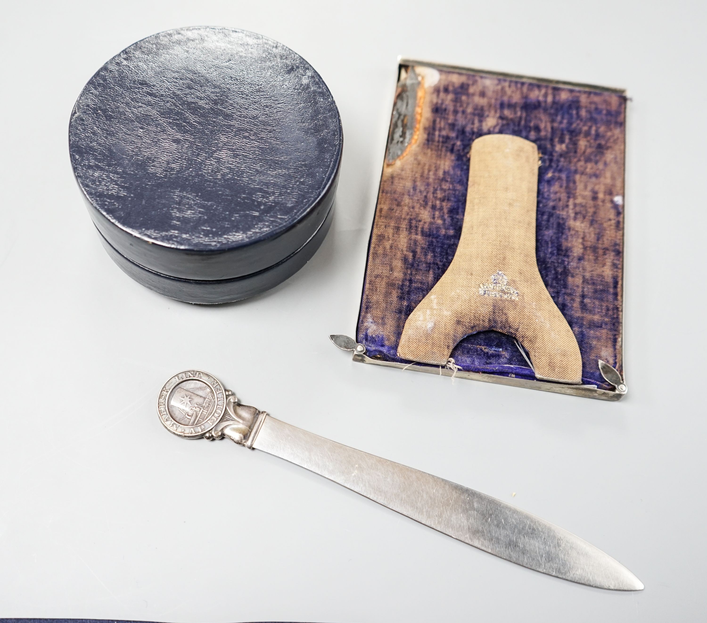 An Edwardian silver mounted photograph frame, 15.5cm, a letter opener with white metal finial and blue leather stud box with Far Eastern embossed white metal panel to lid.
